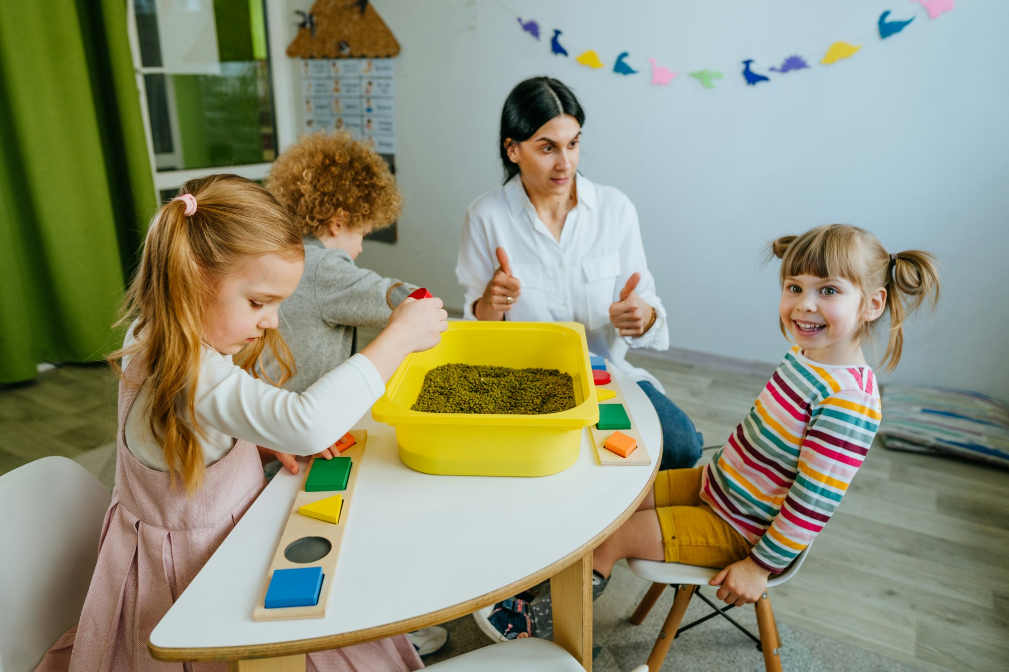 Preschool students playing with beans in kindergarten